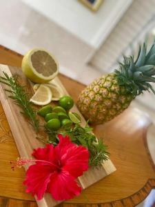 a wooden cutting board with a pineapple and a red flower at Hill view Vacational Rental in Runaway Bay