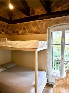 um quarto com 2 beliches e uma janela em Alemarni Parnassos em Polydrosos