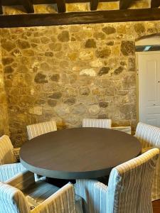 uma mesa e cadeiras em frente a uma parede de pedra em Alemarni Parnassos em Polydrosos