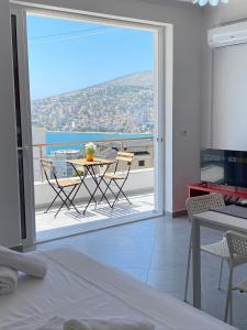 a room with a view of a balcony with a table and chairs at TERRACE VIEW APARTMENTS in Sarandë
