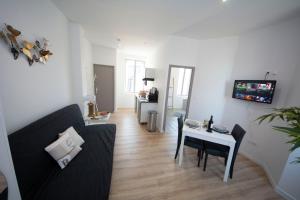 un soggiorno con un divano e un tavolo di IVOIRIA !!! SUBLIME Studio HOME STAGING AU CENTRE VILLE !!! a Saint-Quentin