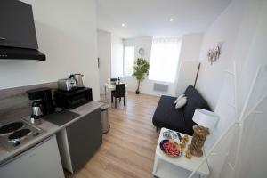 una cucina e un soggiorno con un divano e un tavolo di IVOIRIA !!! SUBLIME Studio HOME STAGING AU CENTRE VILLE !!! a Saint-Quentin Altre 2 foto