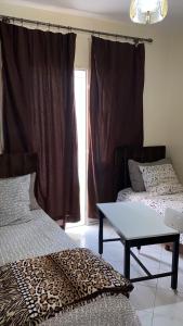 una camera con due letti e un tavolo e una finestra di KHAWARIZMI 5 ad Agadir