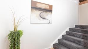 a staircase with a painting and a plant on the wall at Breakers Block 5 Unit 6 in Yamba