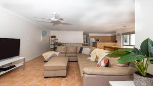 a living room with a couch and a flat screen tv at Breakers Block 5 Unit 6 in Yamba