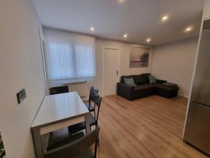 uma sala de estar com um sofá e uma mesa em 136A Apartamento moderno en Playa San Lorenzo em Gijón
