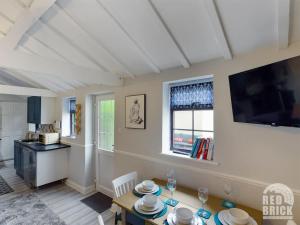 a living room with a table and a kitchen at The Lodge at Pickford House NEC and B'Ham Airport, Coventry in Coventry