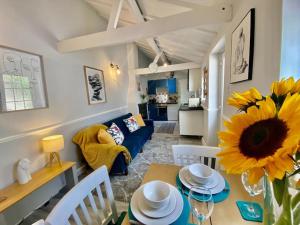 a living room with a table with a sunflower at The Lodge at Pickford House NEC and B'Ham Airport, Coventry in Coventry