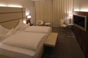 a hotel room with a bed and a flat screen tv at Hotel Am Blauen Wunder in Dresden