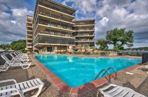 a swimming pool in front of a building at Bright Waterfront Condo with Resort Amenities! in Lake Ozark