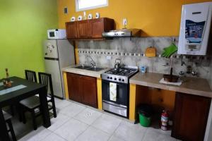 a kitchen with a stove and a sink and a refrigerator at Lo de Kami in Ushuaia