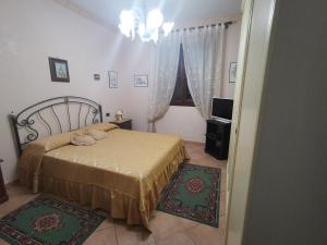 een slaapkamer met een bed en een kroonluchter bij B&B La Fenice in Termini Imerese