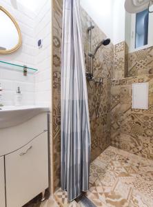 La salle de bains est pourvue d'une douche et d'un lavabo. dans l'établissement Budapest Avenue Apartment, à Budapest