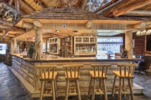 a bar in a log cabin with wooden stools at Ironwood Superior Home about 4 Mi to Big Powderhorn! in Ironwood