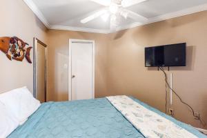 1 dormitorio con 1 cama y TV de pantalla plana en Victorian Condos Tranquility at the Victorian 3224 en Galveston