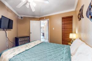 1 dormitorio con 1 cama y TV de pantalla plana en Victorian Condos Tranquility at the Victorian 3224 en Galveston