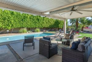 patio z parasolem i basenem w obiekcie House of Jojo w mieście Palm Springs