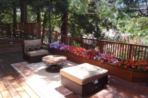 una terraza con dos bancos y un ramo de flores en Little Paradise with Sauna Garden near Downtown, en Saratoga