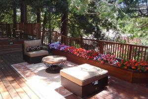 a deck with two benches and a bunch of flowers at Little Paradise with Sauna Garden near Downtown in Saratoga