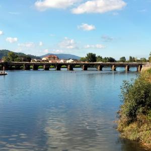 un puente sobre un río con agua azul en Virxen do Carmen 7 alojamiento, en Puentecesures