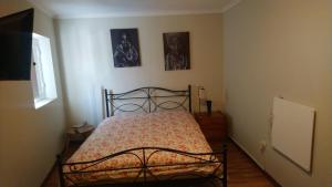 1 dormitorio con 1 cama y 2 cuadros en la pared en A Casinha rústica com todo o conforto en Aldeia da Ponte