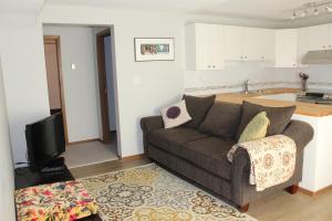 a living room with a couch and a kitchen at A Gem Inn the Rockies in Jasper