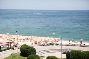 a view of a beach with umbrellas and the ocean at Hotel Cristallo in Fano