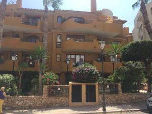 ein großes gelbes Gebäude mit Blumen davor in der Unterkunft Panorama Park, Punta Prima, 5 star Luxury 2 bedroom Apartment like no other in Alicante