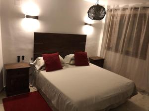 ein Schlafzimmer mit einem großen Bett mit zwei roten Kissen in der Unterkunft Panorama Park, Punta Prima, 5 star Luxury 2 bedroom Apartment like no other in Alicante