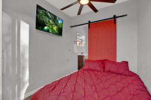 a bedroom with a red bed with a ceiling fan at Best little Fredericksburg Bed and Breakfast Unit2 in Fredericksburg