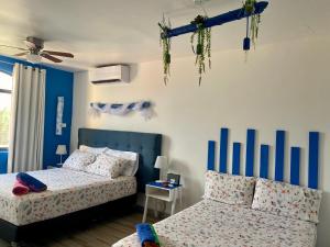 a bedroom with two beds and blue and white walls at Tropical apartment in Canc&uacute;n