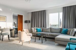 a living room with a couch and chairs and a table at Best Western Plus Hotel Plaza in Västerås