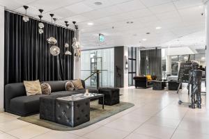 a living room with a couch and a table at Best Western Plus Hotel Plaza in Västerås