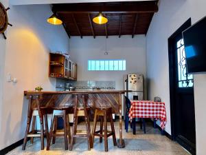 una cocina con barra de madera con taburetes en Cabaña La Aldea - Santorini Colombiano en Doradal