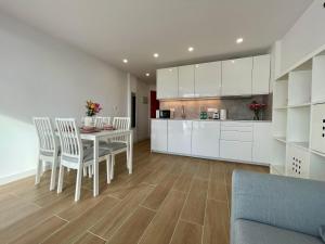 a kitchen with white cabinets and a table and chairs at Malibu Park 2115 - Ocean View in Adeje