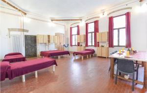 una grande stanza con letti rossi e tavoli di Gorgeous Apartment In Monselice With Kitchenette a Monselice