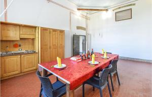 una cucina con tavolo rosso con sedie e candele di Gorgeous Apartment In Monselice With Kitchenette a Monselice