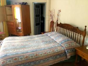 1 dormitorio con 1 cama y vestidor en Casa de Huespedes Concordia en Cochabamba