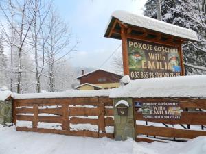 a sign in the snow next to a fence at Willa Emilia in Wisła