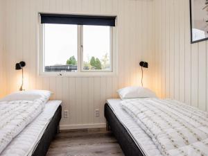dwa łóżka w pokoju z oknem w obiekcie Holiday home Haderslev XLVII w mieście Haderslev