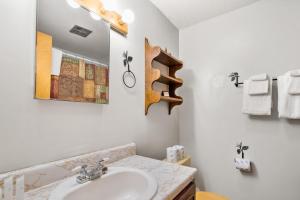 a white bathroom with a sink and a mirror at Cozy Condo by Tripp Lake in Warrensburg +30 photos