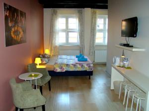 a small room with a bed and a table and chairs at U Romana in Poznań