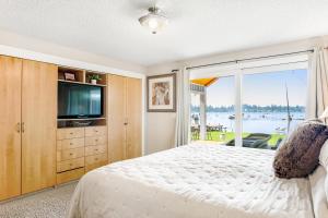 um quarto com uma cama, uma televisão e uma janela em Lake Tapps Sunsets em Bonney Lake