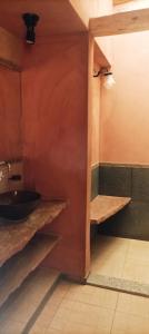 łazienka z umywalką i drewnianymi półkami w obiekcie La Elegida w mieście Tilcara