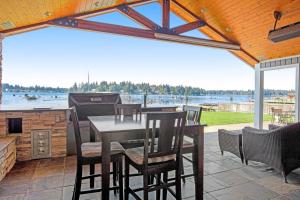 um pátio com uma mesa, cadeiras e comodidades para churrascos em Lake Tapps Sunsets em Bonney Lake