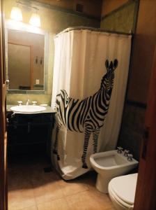 łazienka z zasłoną prysznicową zebra i toaletą w obiekcie La Elegida w mieście Tilcara