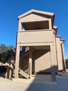 un edificio con un gran garaje con una escalera en Home Apartments en Seline