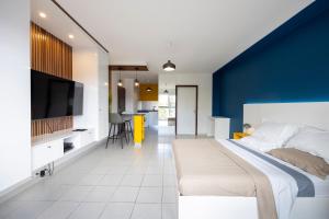 een slaapkamer met een groot bed met een blauwe muur bij Lumina - DestinationGuyane - Séjours d'affaires - Services personnalisés in Cayenne
