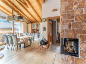 a living room with a fireplace and a table and chairs at Maier Alm in Wald im Pinzgau