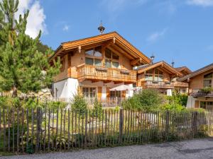 une maison en bois avec une clôture devant elle dans l'établissement Maier Alm, à Wald im Pinzgau
